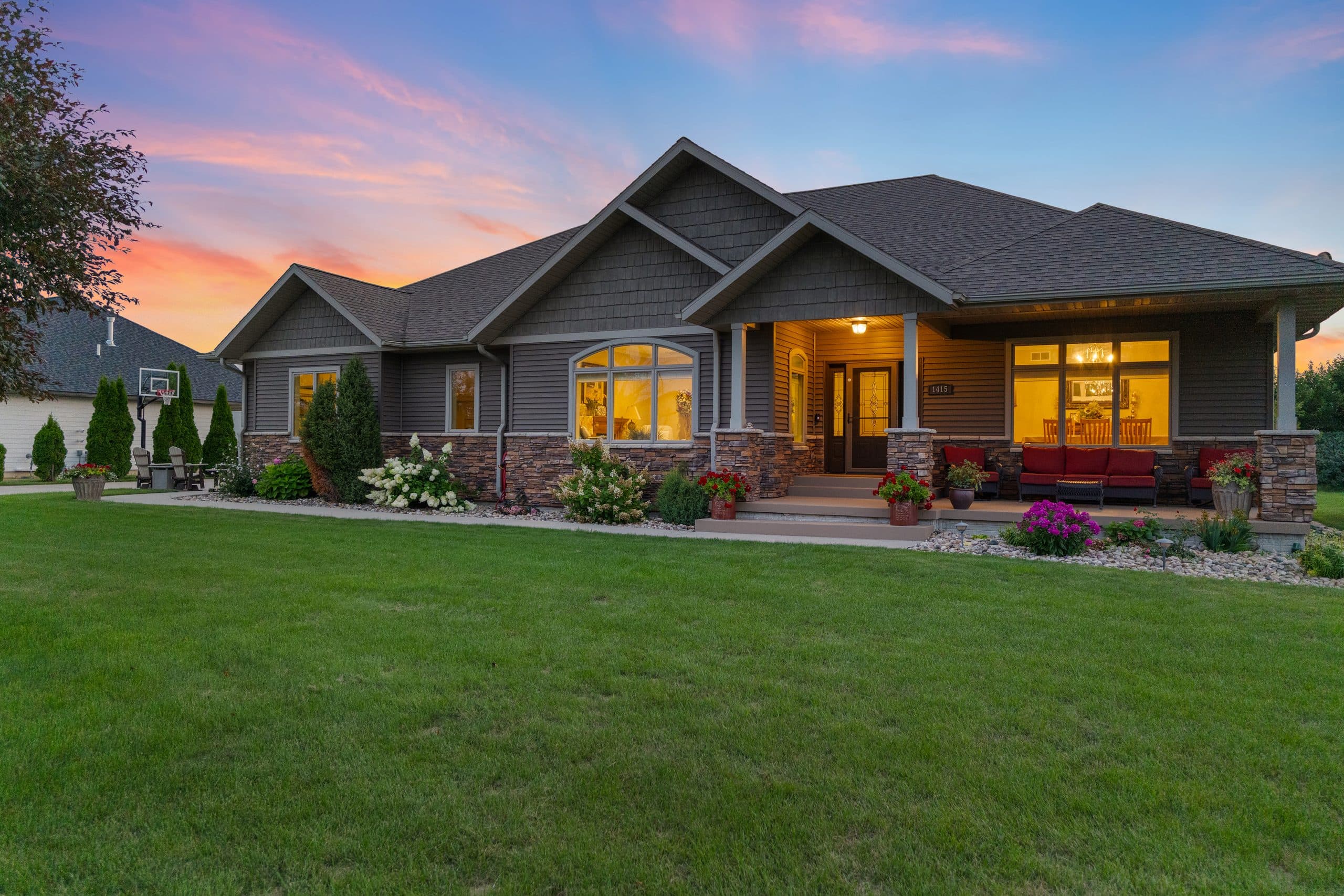 Craftsman ranch home at twilight with lit windows