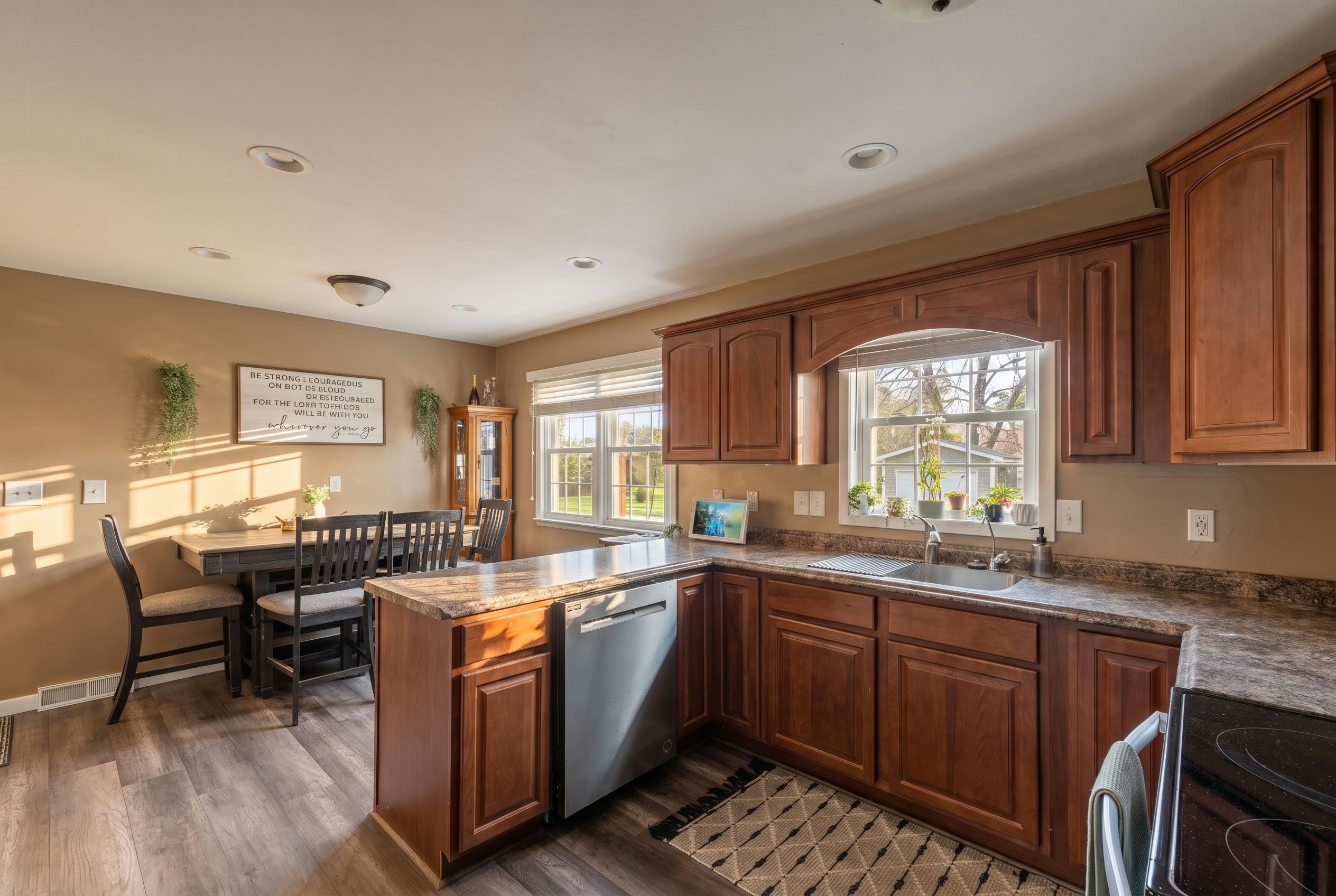 Kitchen and dining area with warm wood cabinetry, durable counters, and a comfortable breakfast bar