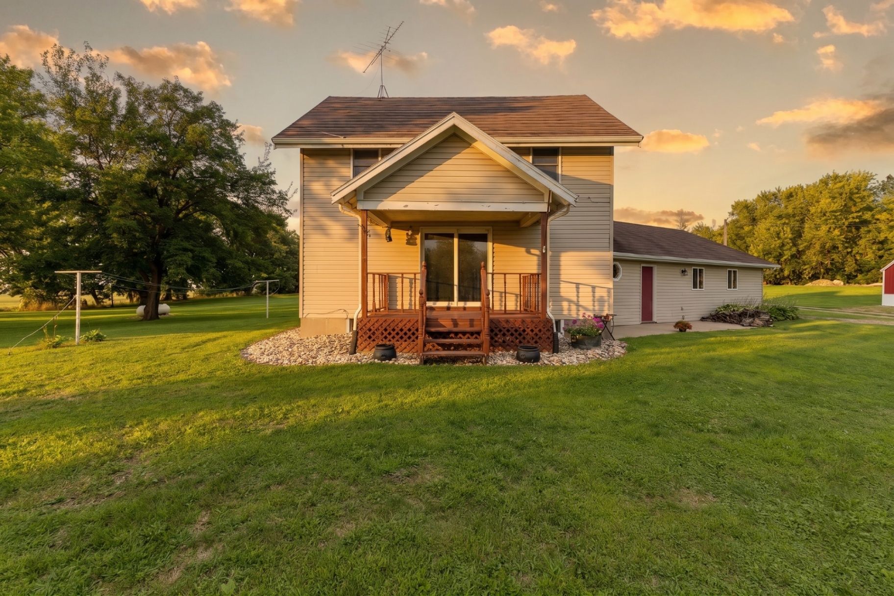 Clear Lake-area home with a spacious backyard and wooden deck surrounded by open lawn at sunset
