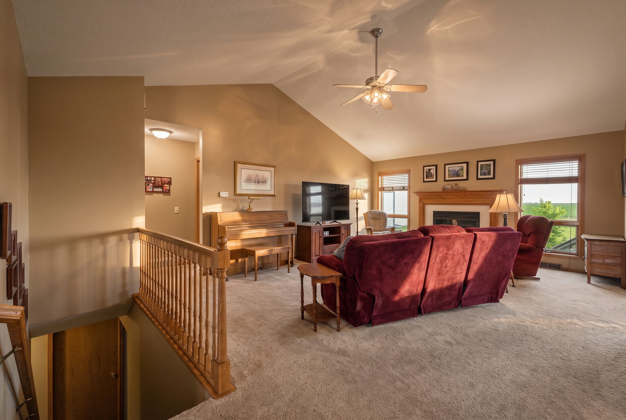 Bright, inviting living area with a fireplace, piano, and large windows in Clarion